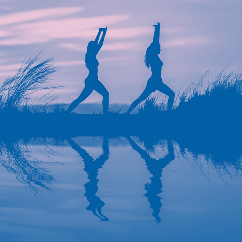 Picture of two women doing yoga on the beach